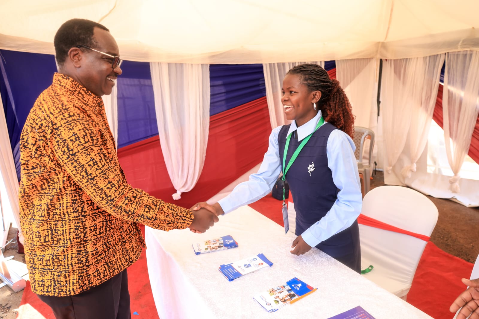 A visitor is welcomed at The Cornerstone Foundation's stand during the Gusii Education Stakeholders Convention